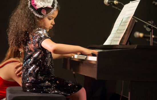 una niña con un vestido tocando el piano